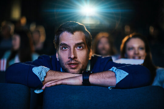 Young Caucasian man watching a movie in a movie theater