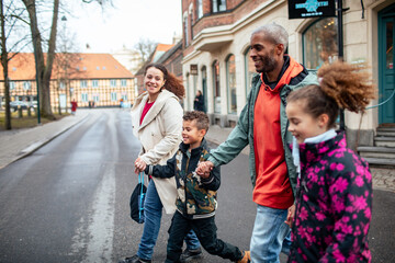 Young blended family walking in the city while on vacation