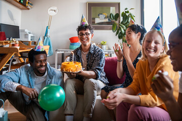 Young and diverse group of friends celebrating a birthday at home
