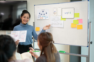 Young smart UX UI designer presenting her idea to the team, presentation during the team meeting.