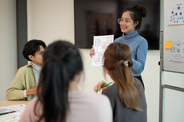 Young smart UX UI designer presenting her idea to the team, presentation during the team meeting.