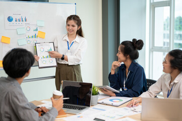 Young energetic businesswoman presenting her project to her coworkers during the meeting.