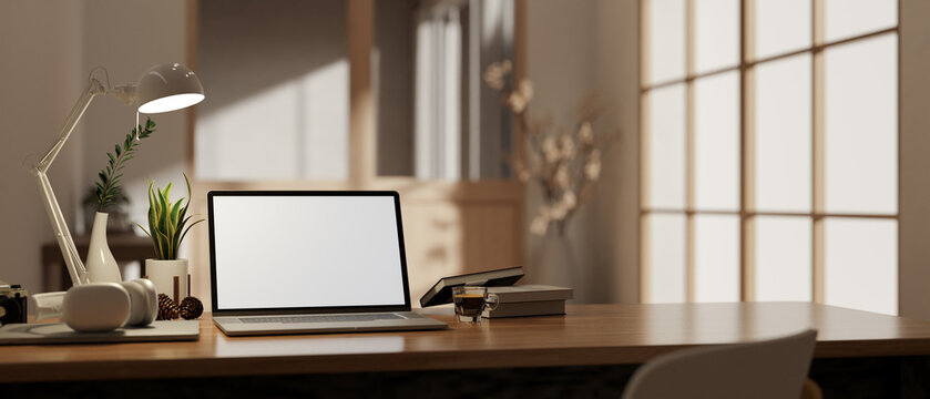 A laptop mockup on a wooden desk with accessories in a modern home office or private office.
