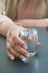 women holding a glass of water on table 