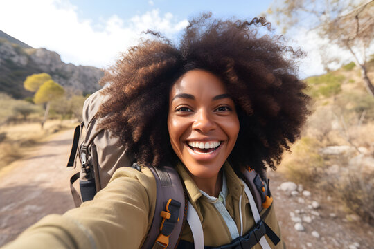 Happy traveller black woman with backpack taking selfie picture in mountains - Travel blogger taking self portrait with smart mobile phone device outside - Life style and technology concept