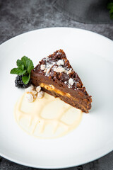 gluten free chocolate cake with nuts, berries and mint on a white plate