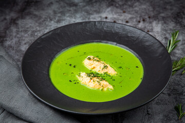  creamy broccoli soup with meat and dill in a black plate
