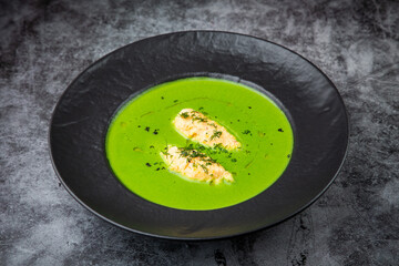  creamy broccoli soup with meat and dill in a black plate