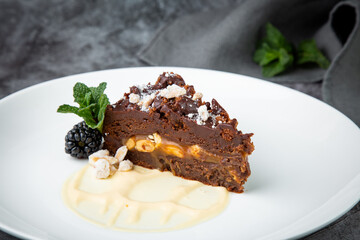 gluten free chocolate cake with nuts, berries and mint on a white plate