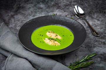  creamy broccoli soup with meat and dill in a black plate