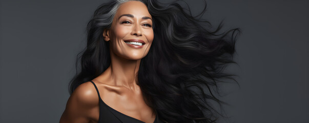 Black middle age woman portrait with healthy face skin. Open smiling beautiful aging mature woman with long hair. Beauty and cosmetics skincare advertising concept