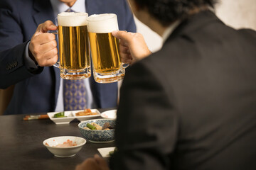 居酒屋で乾杯するビジネスマン　顔無しの手元のクローズアップ