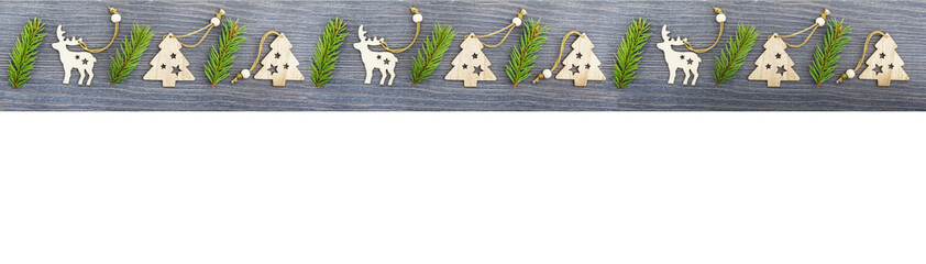 Wooden Christmas and new year toys on Christmas tree branches , top view, copy space, banner, holiday mood.