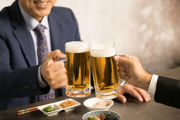 居酒屋で乾杯するビジネスマン　顔無しの手元のクローズアップ