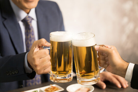 Businessman toasting at a tavern, close-up of faceless hand
