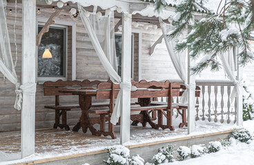 Beautiful wooden furniture on a large terrace. Winter. snow.