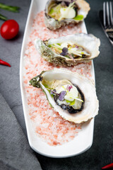 Grilled oysters on red sea salt with lime