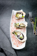 Grilled oysters on red sea salt with lime