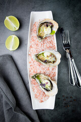 Grilled oysters on red sea salt with lime