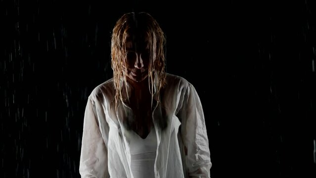 frustrated woman in rain in night, portrait, zooming shot in darkness, frontal view on wet lady