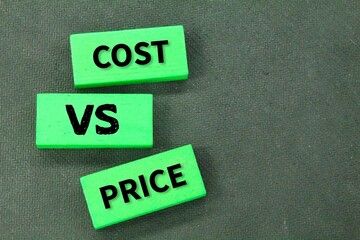 colored wood with the words cost vs price. the concept of calculation management or price...