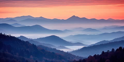 The mountains are shrouded in mist. A twilight shot of autumn mountains under a fading red orange purple sky.