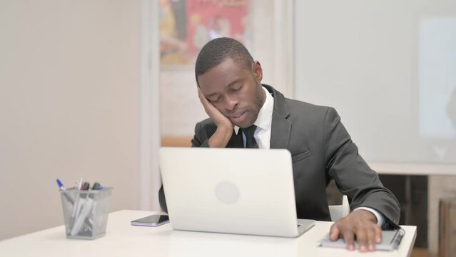 African Businessman Sleeping while Sitting in Office