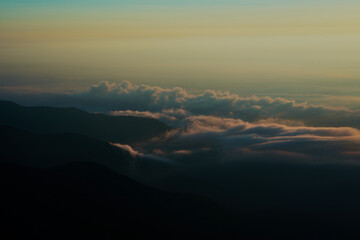 朝焼けに照らされた雲海が山にぶつかる様子