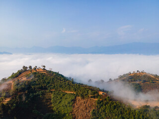 Fototapeta na wymiar Green mountains surrounded by white mist in the morning There is a dirt road to reach. Homestay, tented accommodation Named after Doi Glocelo, Mae Hong Son, north of Thailand It is a popular viewpoint