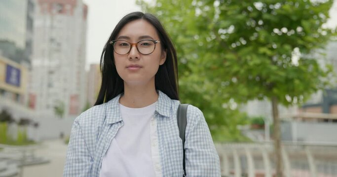 Portrait of Young asian woman wearing casual clothes with backpack on the back at the city