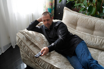 man sitting on sofa and watching tv