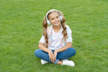 teen girl listen to music. happy childhood. lifestyle of teen girl. music of her childhood. listening to music in headphones outdoor. teen girl listen a song in wireless headphones. enjoy the day