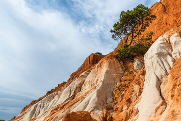 Red cliffs on sandy beach in Algrave, Portugal at sunny day