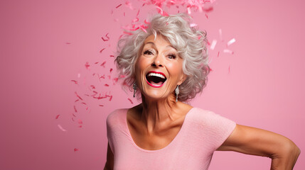 Portrait of mature woman celebrating on pink background