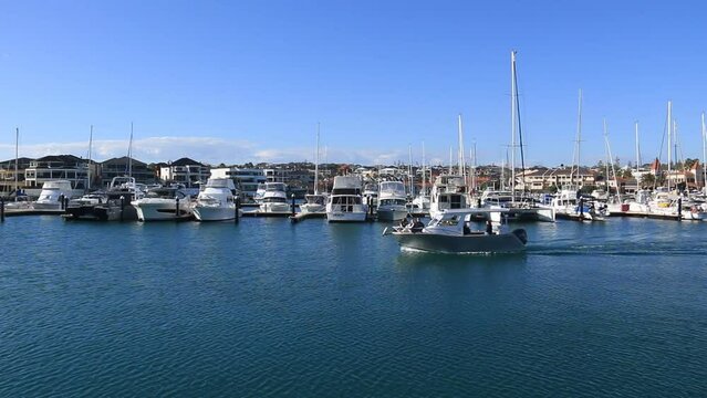 Speedboat making it&rsquo;s way slowly past a row of yachts at Mindarie Marina