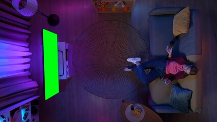 Top view of female sitting on the sofa in the living room, won the video game, TV with Chroma key...