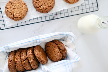 Freshly baked healthy vegan cookie on a cooling rack stand on a table next to milk. View from
