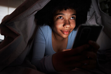 Teenage girl browsing mobile phone in the living room at night