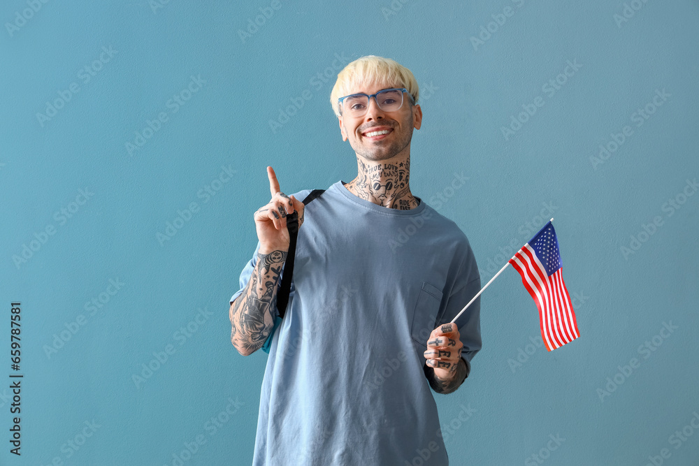 Sticker Male student with USA flag pointing at something on blue background