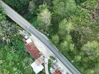 Aerial view of the road passing through the forest, Road through the green forest, Aerial view from above in the forest.