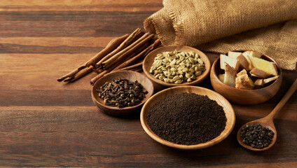 indian tea masala assam powder and ingredient on wood rustic table background. indian assam tea...