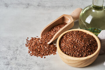 flaxseed linseed oil in wood bowl on white table background. flaxseed linseed oil on white table...