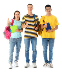 Obraz premium Happy students with backpacks and books showing thumbs-up gesture on white background