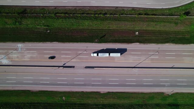 top down aerial of multi trailer truck driving on Interstate 90. Extra-long trucks also called double tow semi trucks. Longer combination vehicles, b train doubles. USA logistics