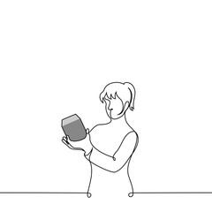 woman stands holding a box in her hand and reads it or examines it in detail - one line art vector. concept receiving a gift, buying small equipment