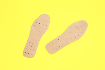 Orthopedic insoles on yellow background