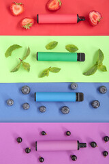 Electronic cigarettes with berries and mint on colorful background