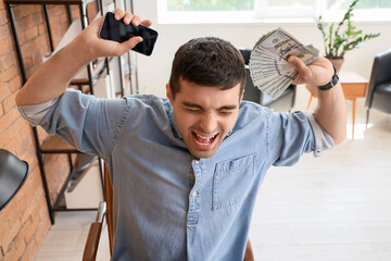Angry young man with money in office