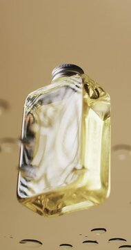 Vertical video of beauty product bottle in water with copy space on yellow background
