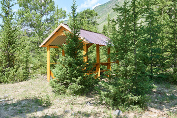 Wooden gazebo in the forest. Weekend out of town in the nature.